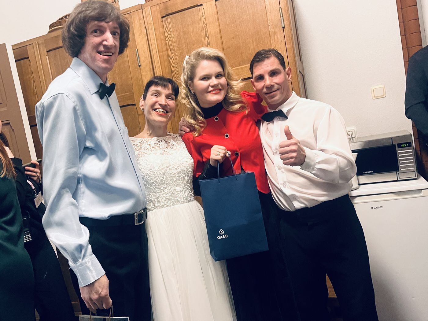 Pasākuma dalībnieki, dejotāji baltajos tērpos ar dziedātāju Anniju Putniņu