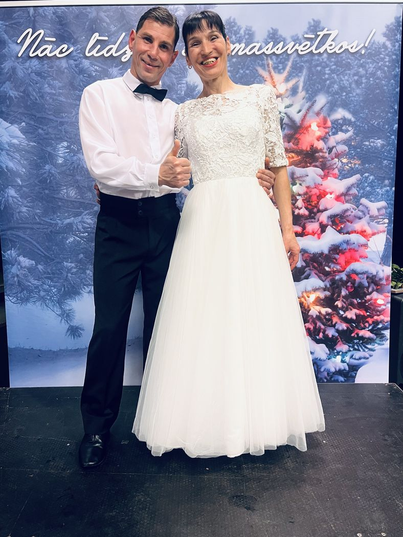 Pasākuma dalībnieki, dejotāji baltajos tērpos smaida