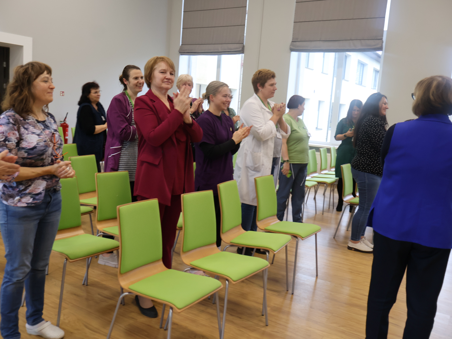 Klausītāji stāvus aplaudē kolēģei