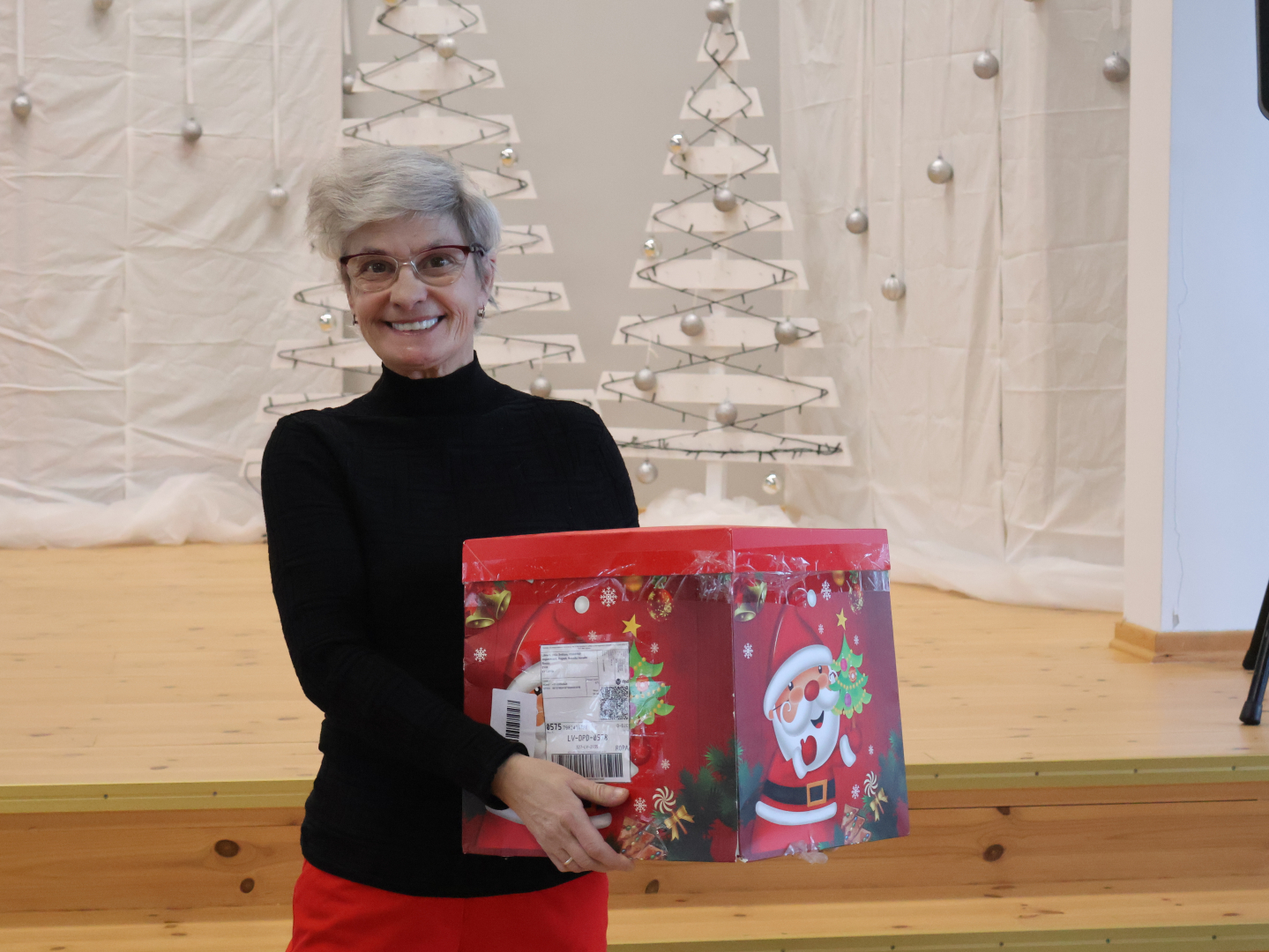 Smaidīga iedzīvotāja ar dāvanu rokās