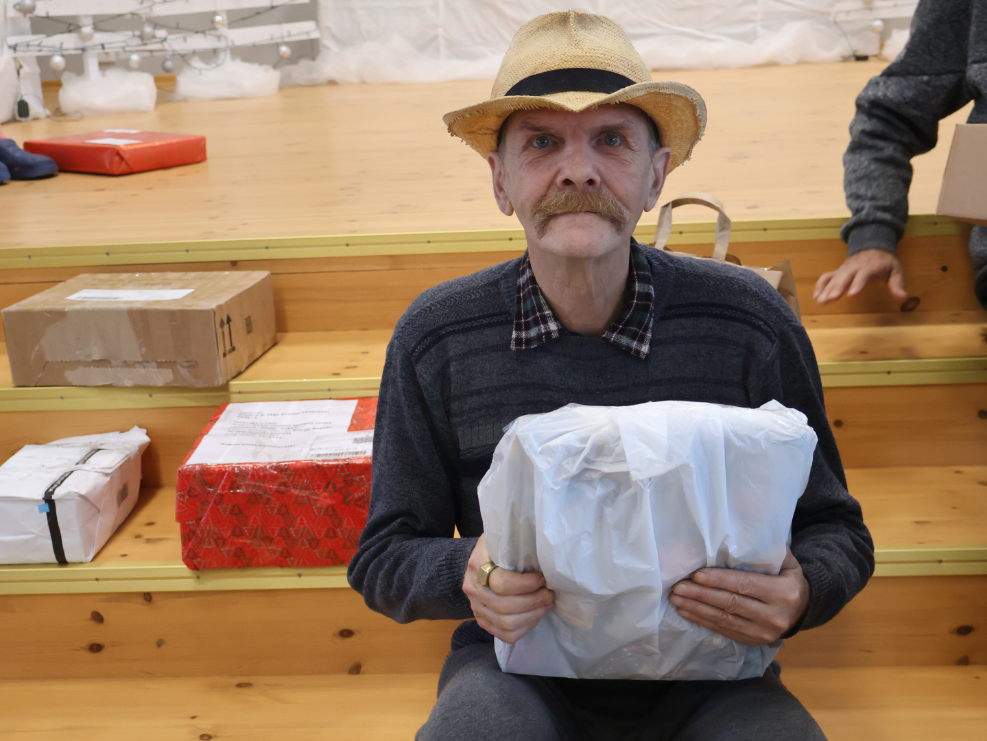 Smaidīgs iedzīvotājs ar dāvanu rokās