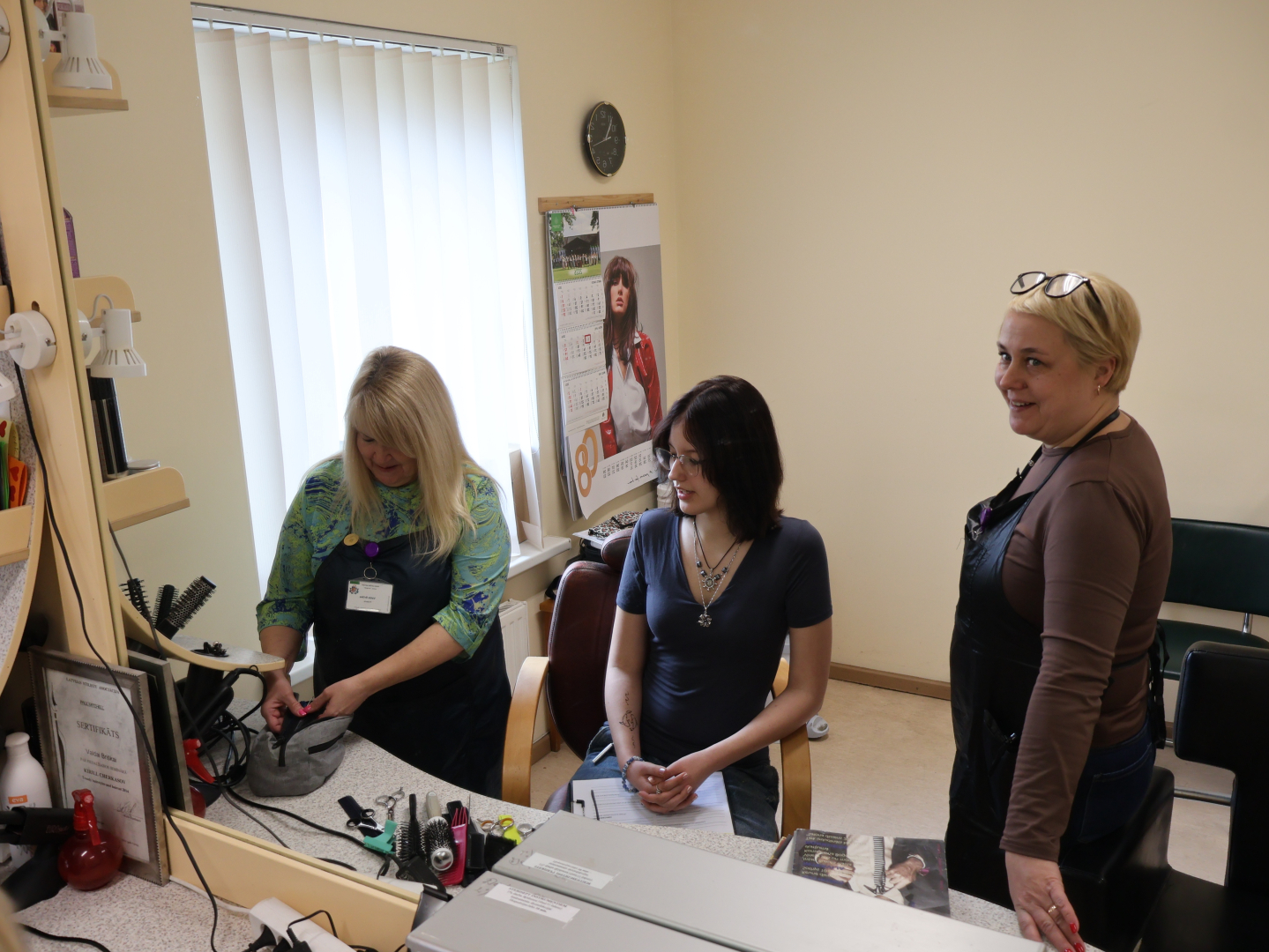 darbinieki iepazīstina jaunieti ar friziera darbu