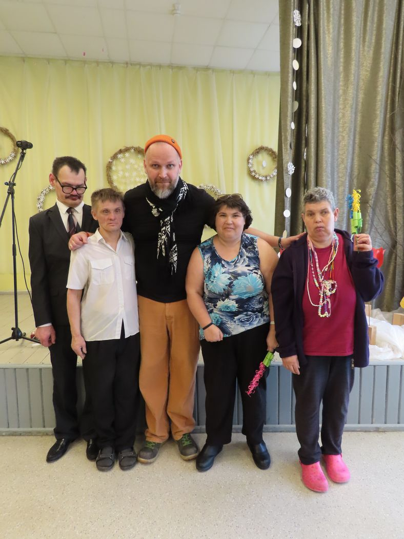 Četri iedzīvotāji fotografējas ar viesi mūziķi