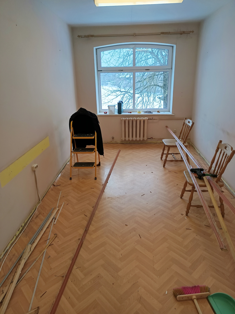 Iedzīvotāju istaba pirms remonta veikšanas, nolietojies grīdas segums un sienu krāsa