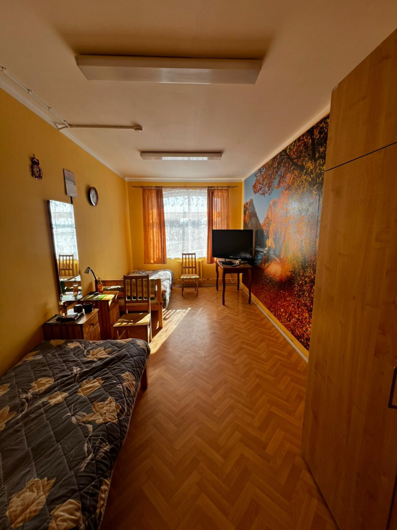 Istaba pēc remontdarbu veikšanas. Sienas krāsojums atjaunots uz gaiši dzelteno, Vienu sienu rotā fototapete