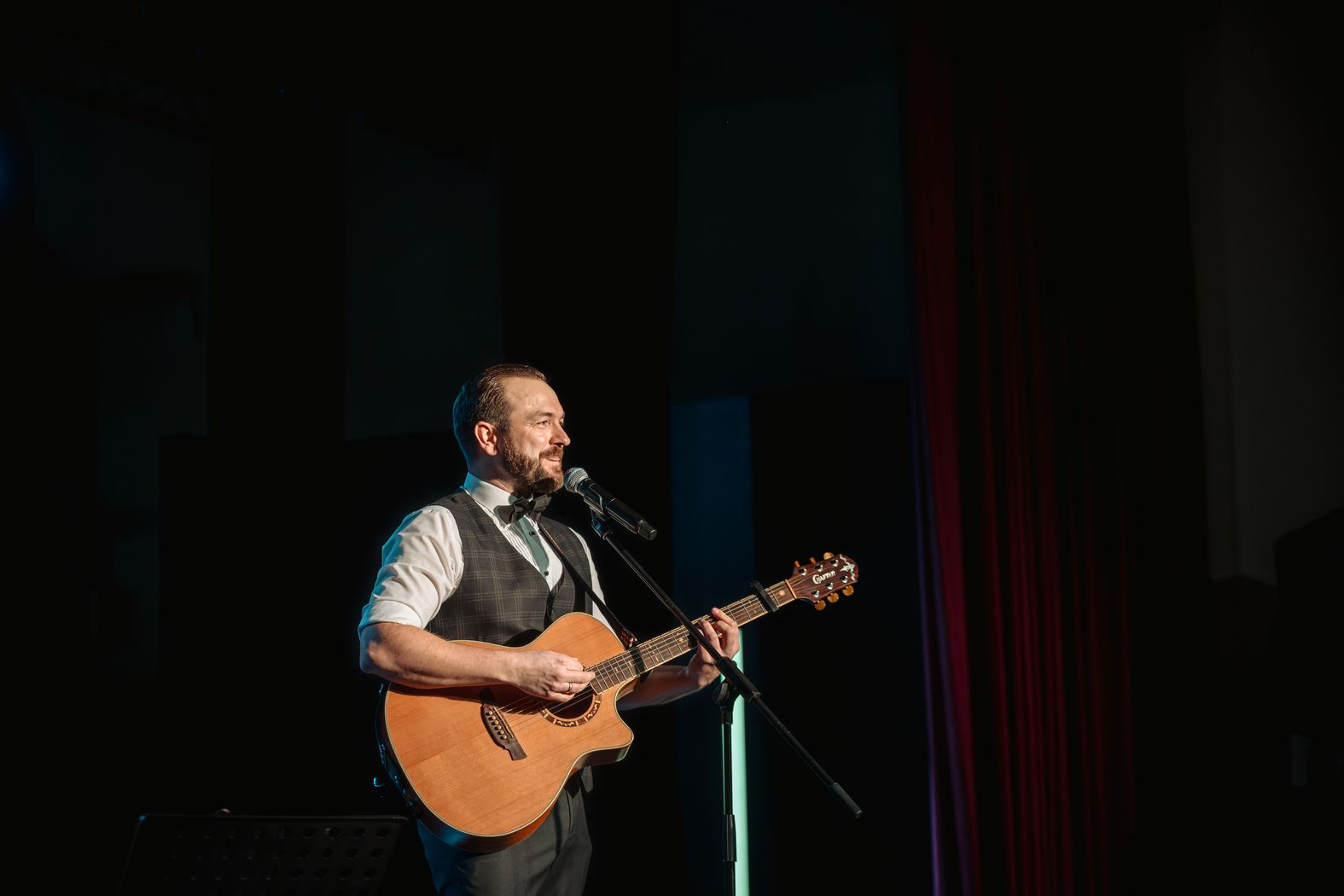 Pasākuma vadītājs Kristaps Rasims spēlē ģitāru un dzied