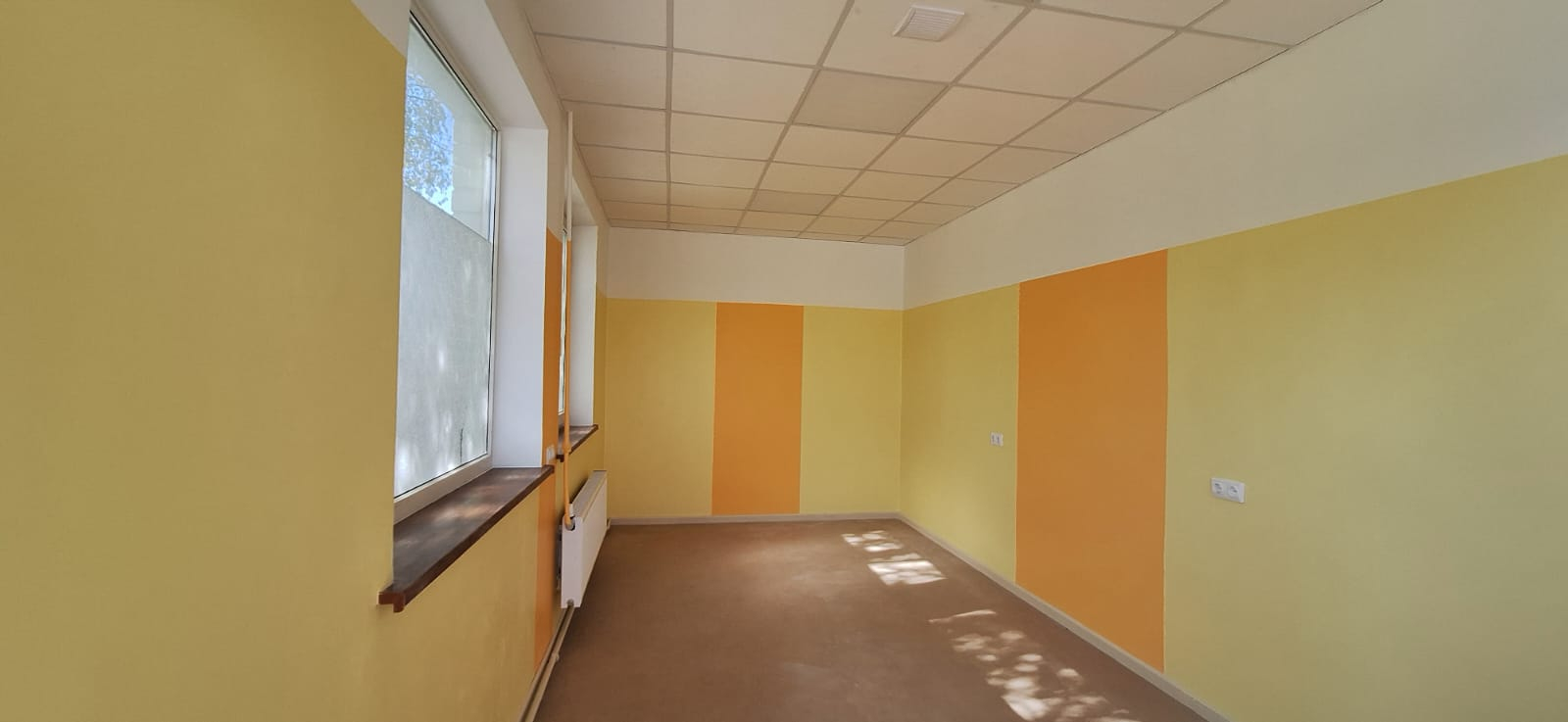 Telpa pēc remonta. Gaiša, sienas nokrāsotas dzeltenos un oranžos toņos.