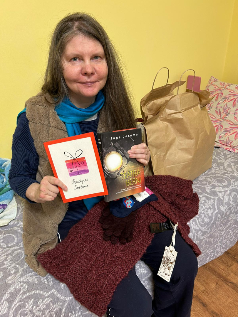 Smaidīga iedzīvotāja ar dāvanu rokās