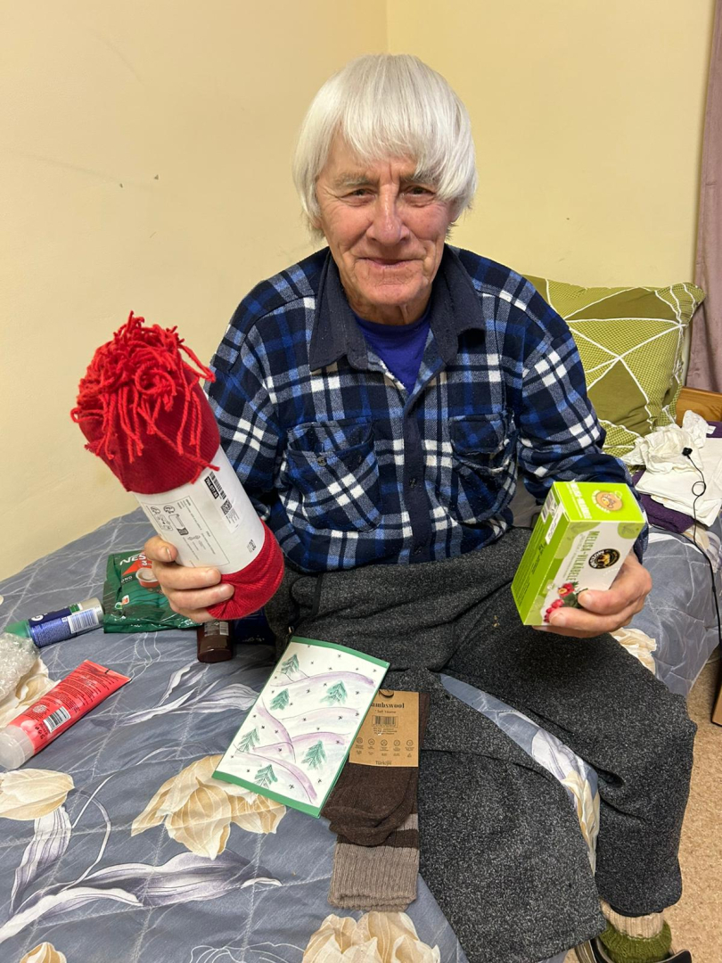 Smaidīgs iedzīvotājs ar dāvanu rokās