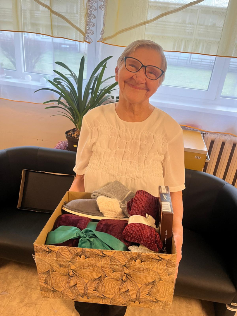 Smaidīga iedzīvotāja ar dāvanu rokās