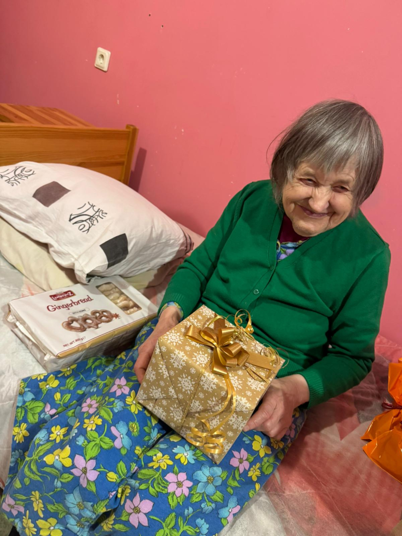 Smaidīga iedzīvotāja ar dāvanu rokās