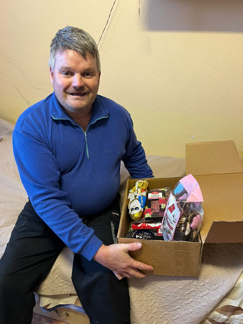 Smaidīgs iedzīvotājs ar dāvanu rokās