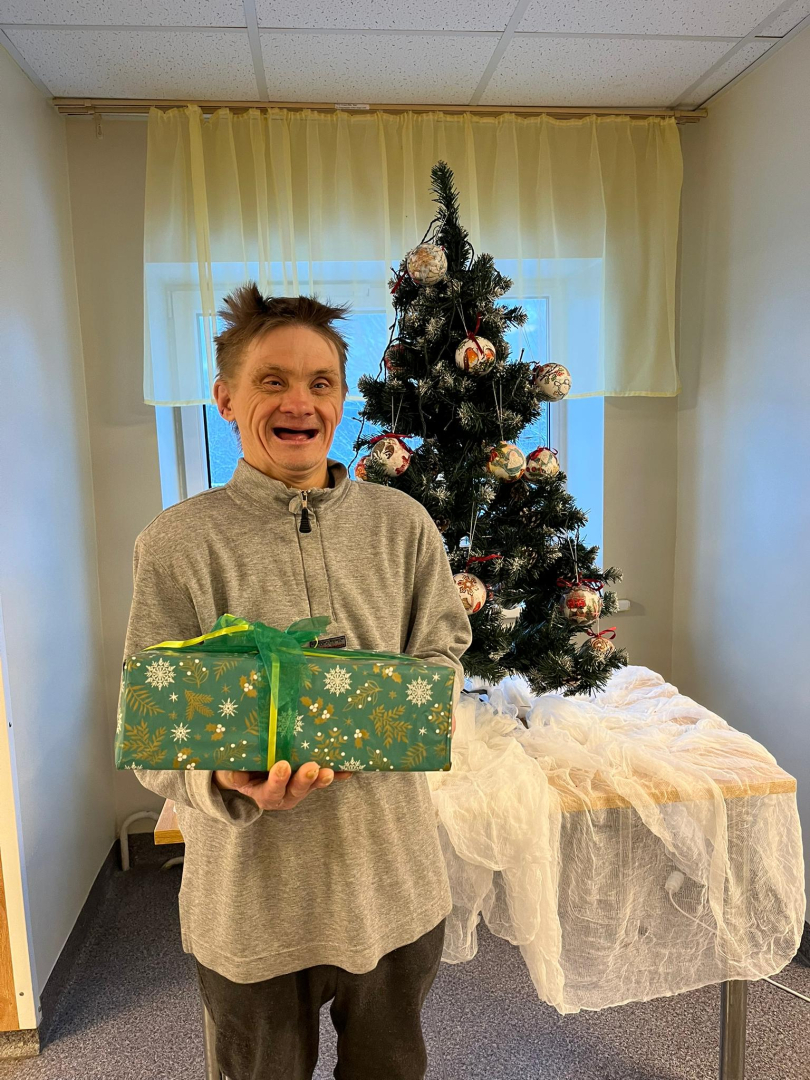 Smaidīgs iedzīvotājs ar dāvanu rokās