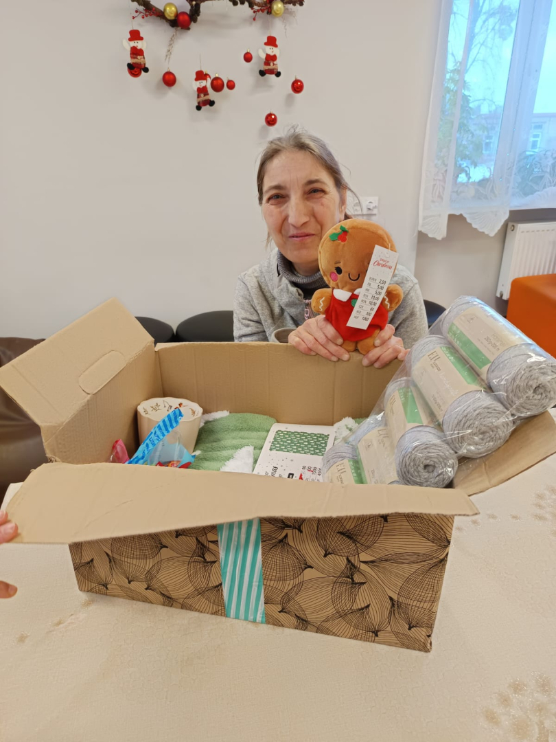 Smaidīga iedzīvotāja ar dāvanu rokās