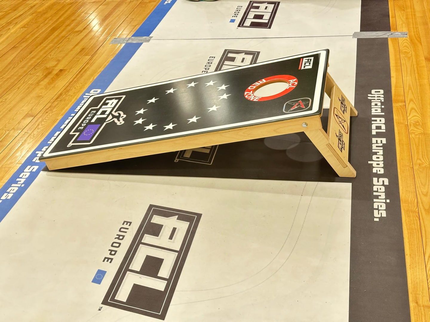 Kornhola pamatne dēlis uz sporta halles grīdas 