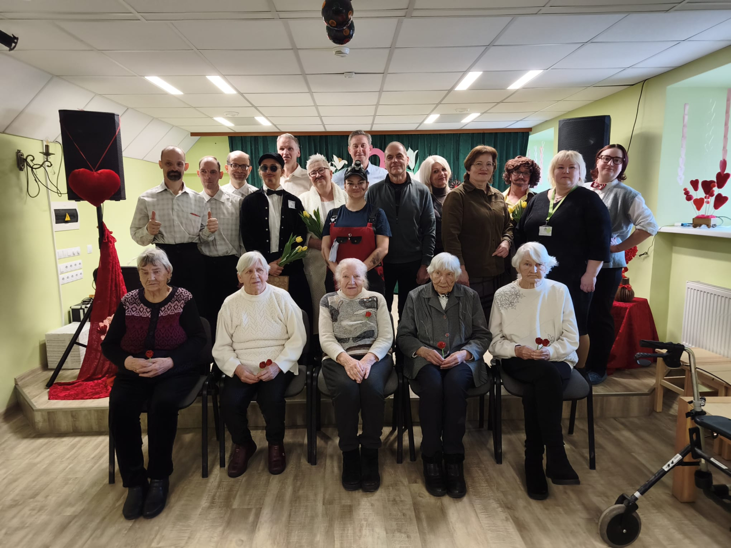 Pasākuma dalībnieku kopbilde. Visi skatās kamerā un smaida.