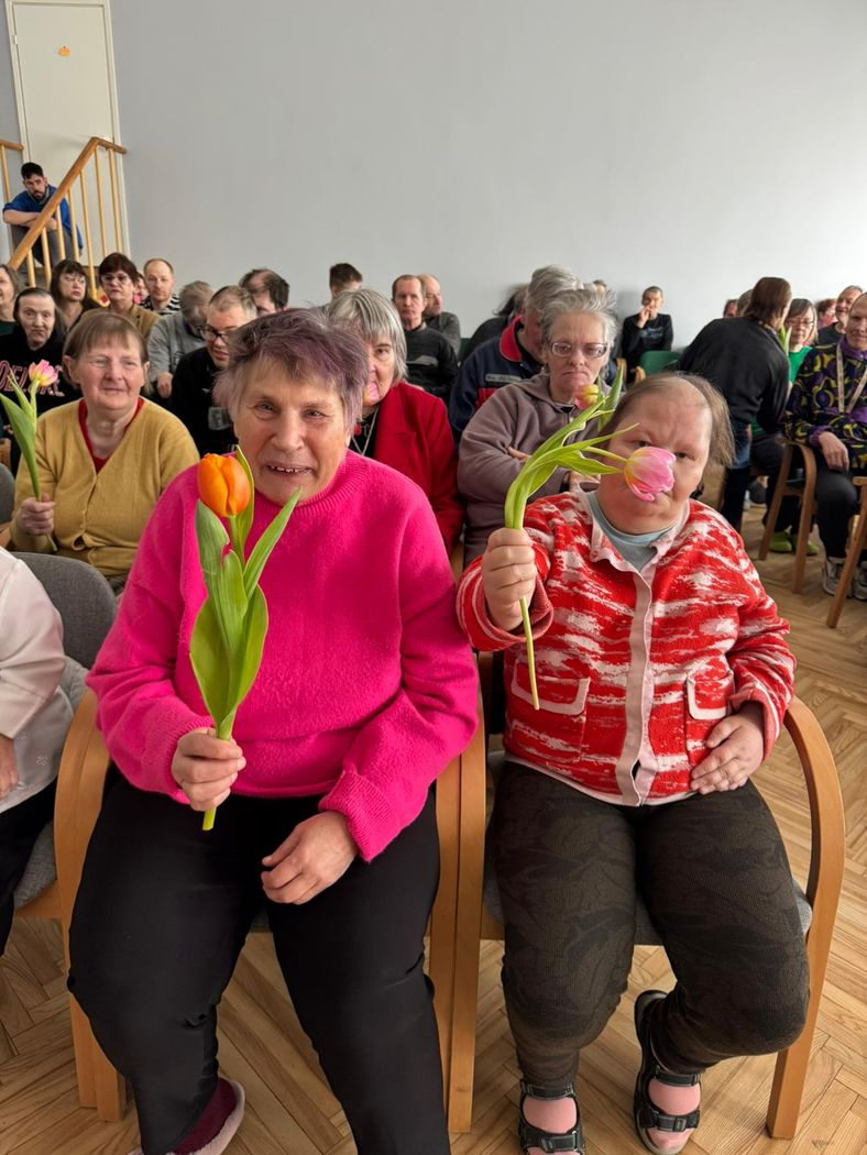 Divas dāmas ar ziediem smaida