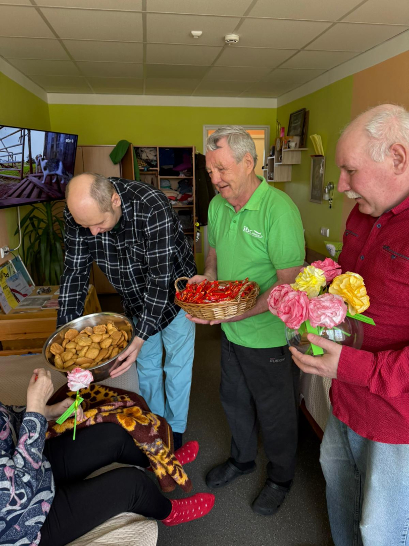 Trīs kungi ar gardumu groziem un ziediem rokās. iepriecina dāmu sieviešu dienā