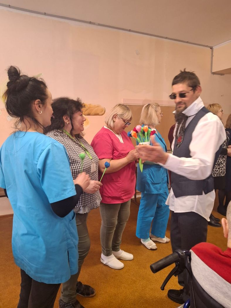 Kungs pasniedz dāmām ziedus