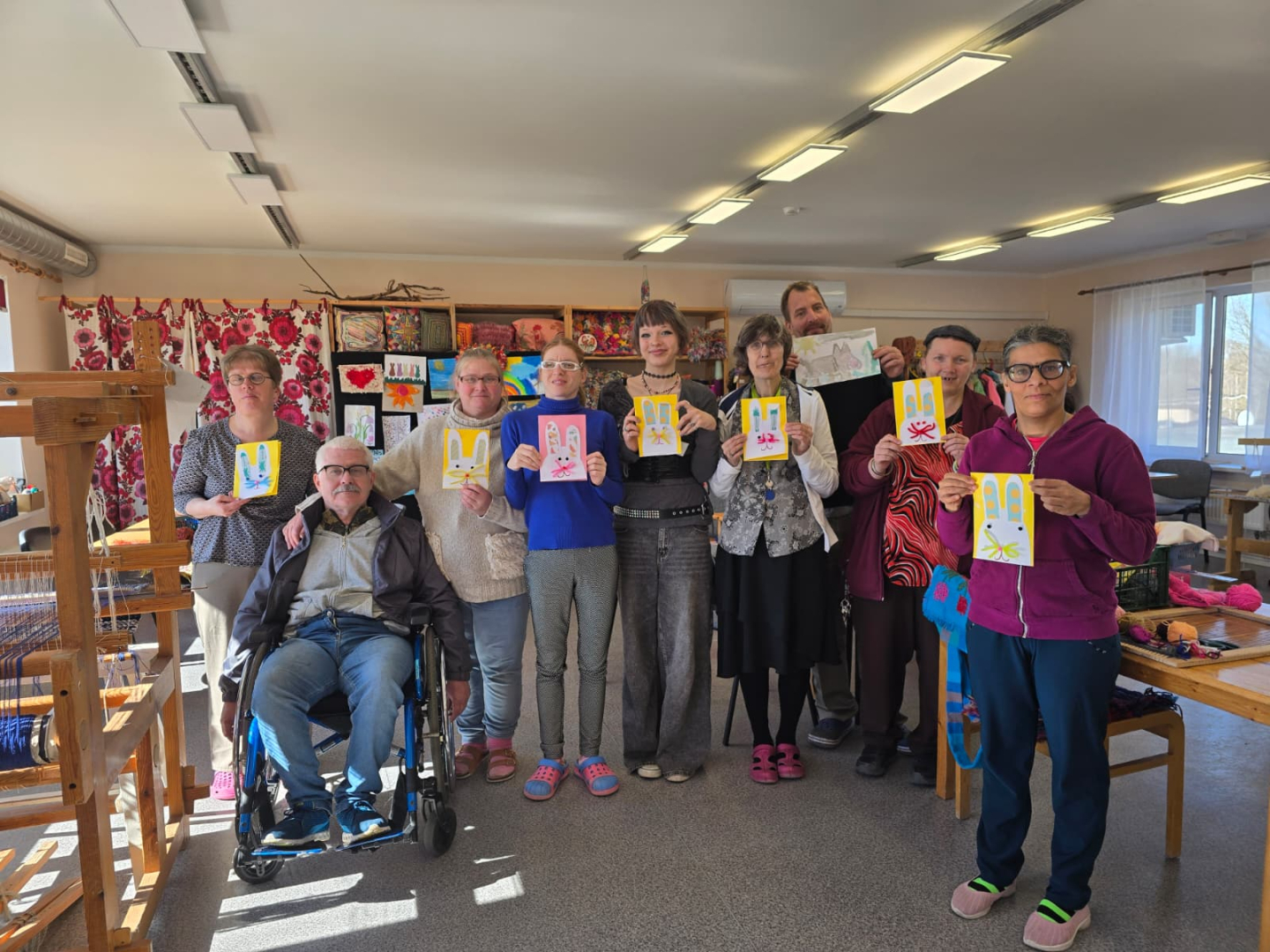 Iedzīvotāji un jauniete rāda kopā nodarbībā sagatavotās kartītes