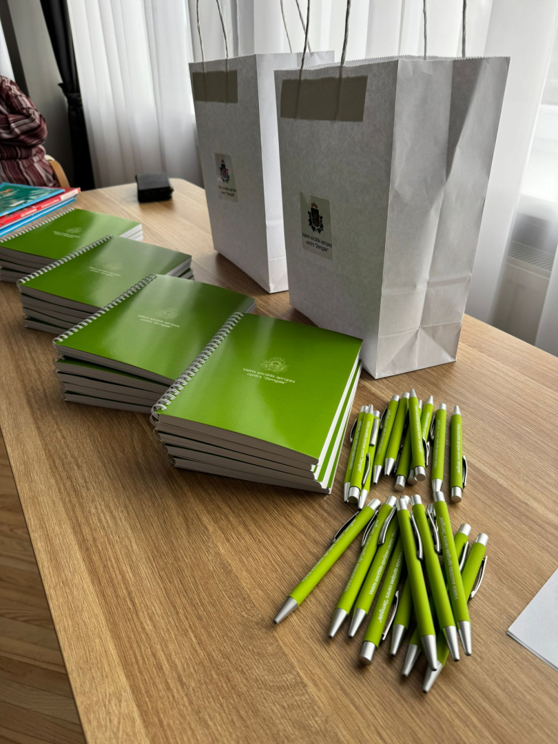 Iestādes reprezentācijas materiāli zaļi bloknoti un pildspalvas ar iestādes logotipu