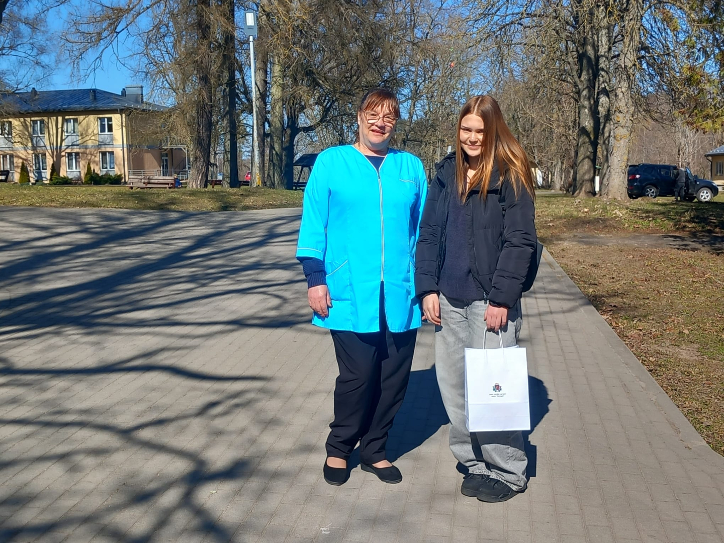 Darbinieks un jauniete stāv ārā