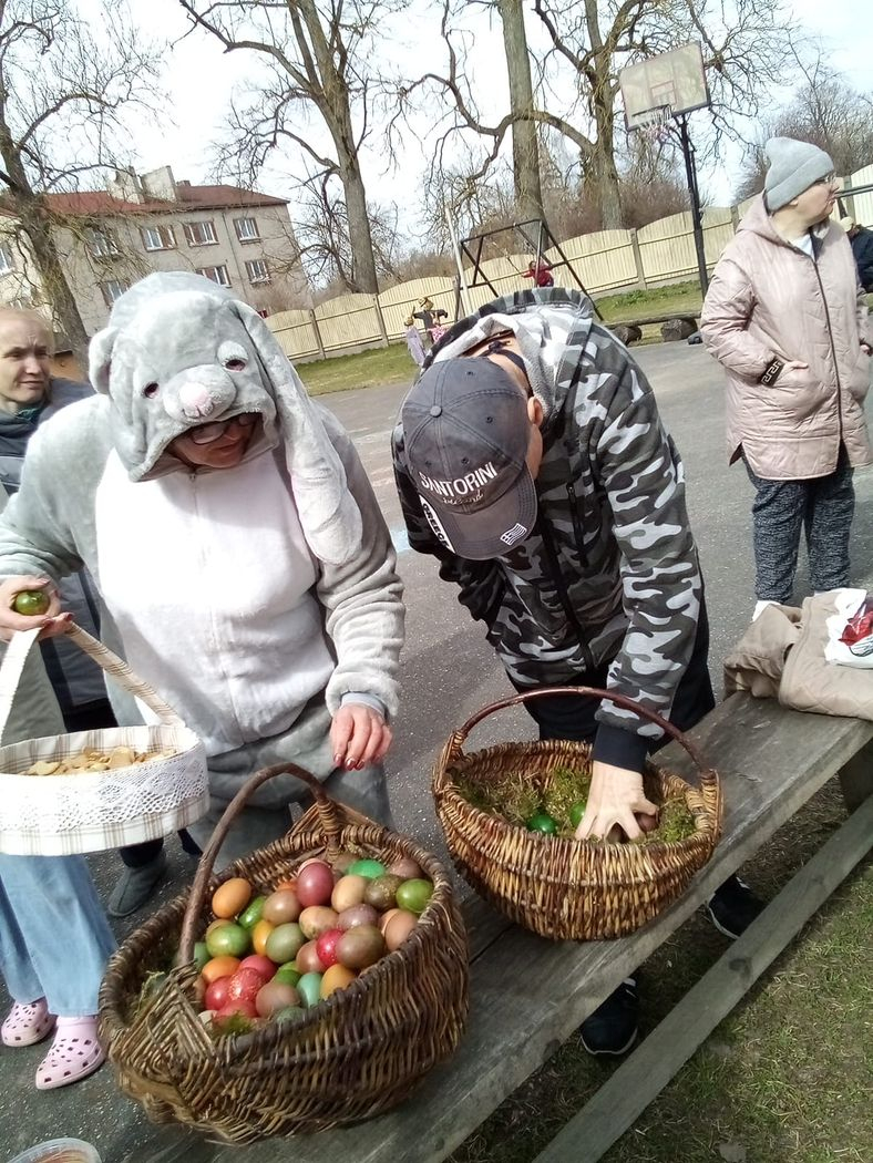 Divi cilvēli ņem krāsotās olas no diviem lielajiem groziem