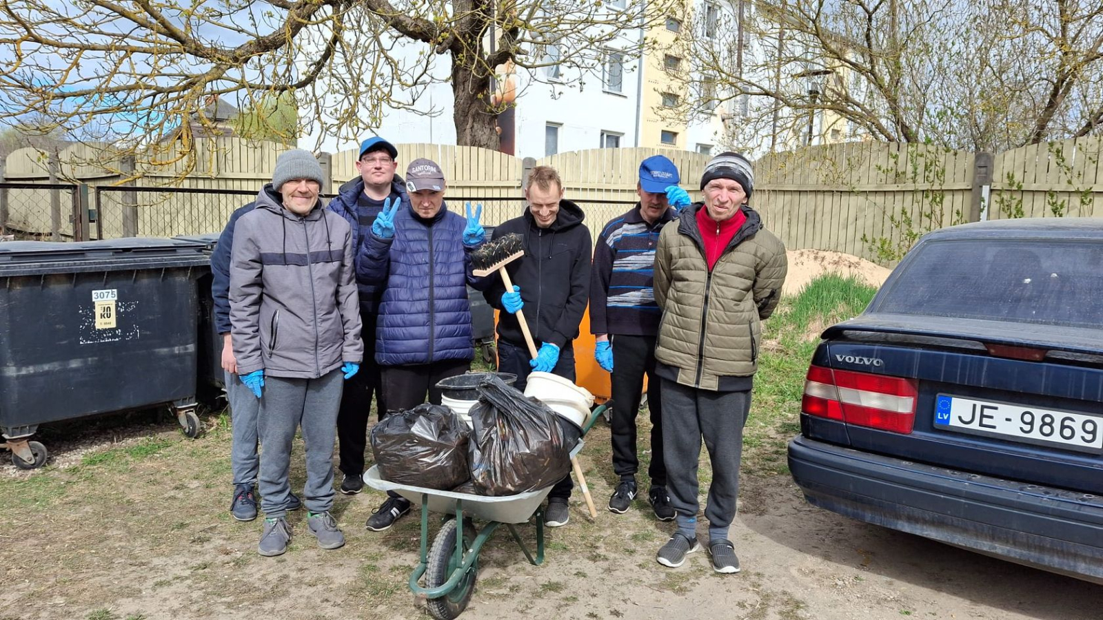 Cilvēki veic teritorijas uzkopšanas darbus