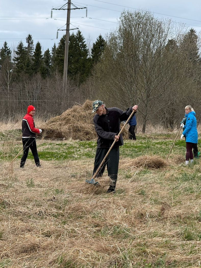 Cilvēki veic teritorijas uzkopšanas darbus