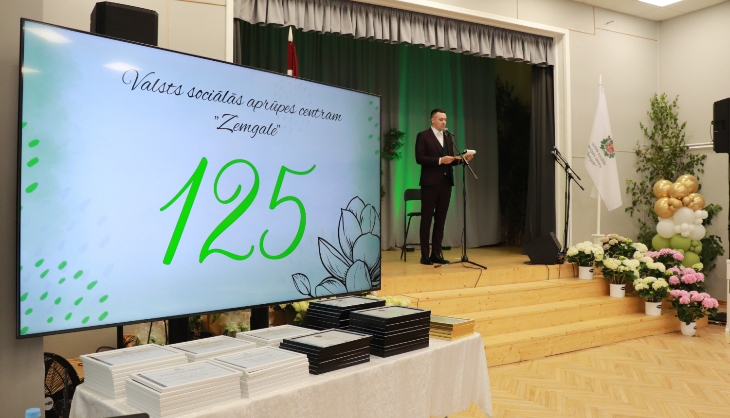 Uz skatuves iestādes direktors saka svētku uzrunu