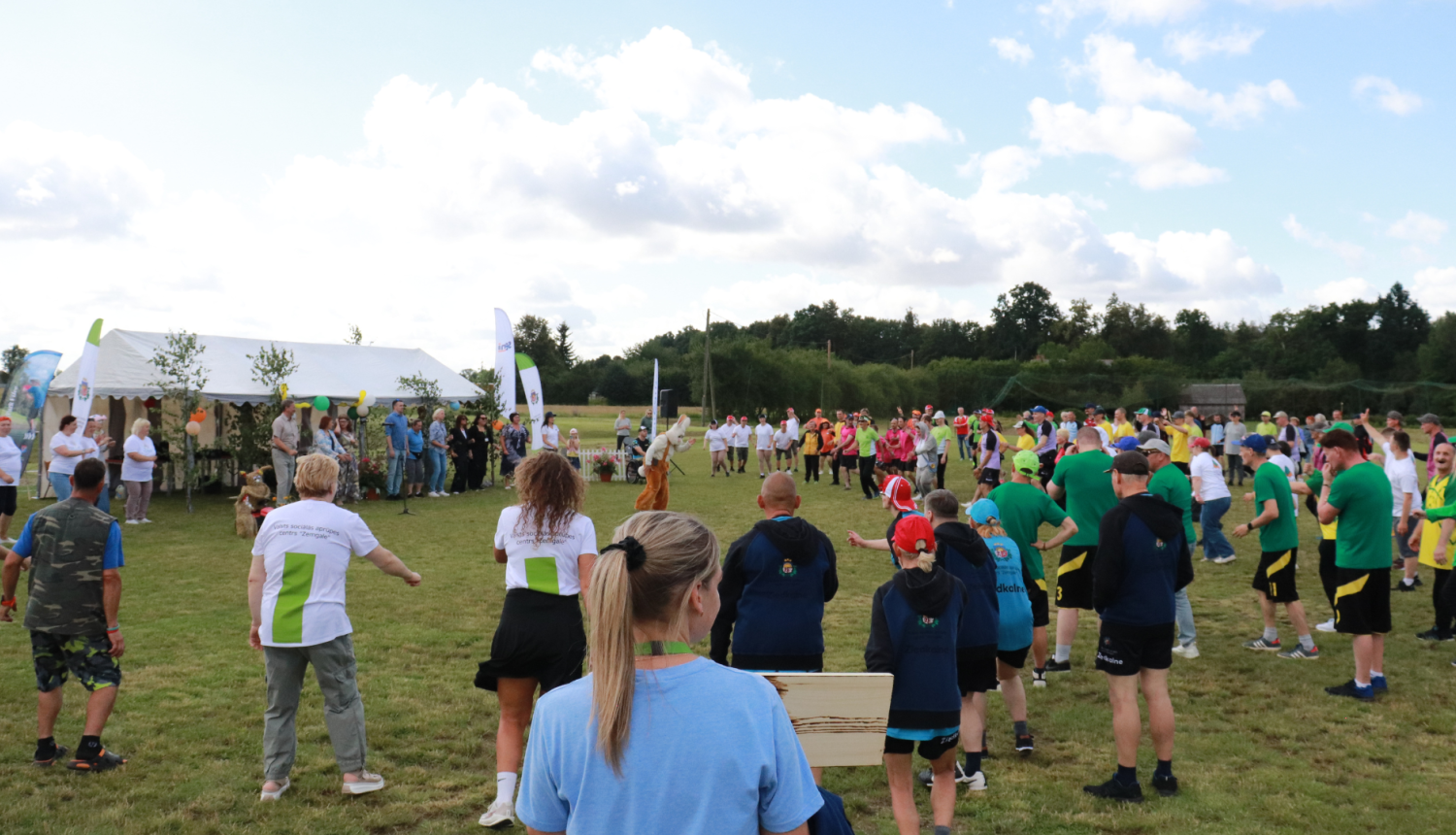 Lielajā pļavā visi pasākuma dalībnieki vingro