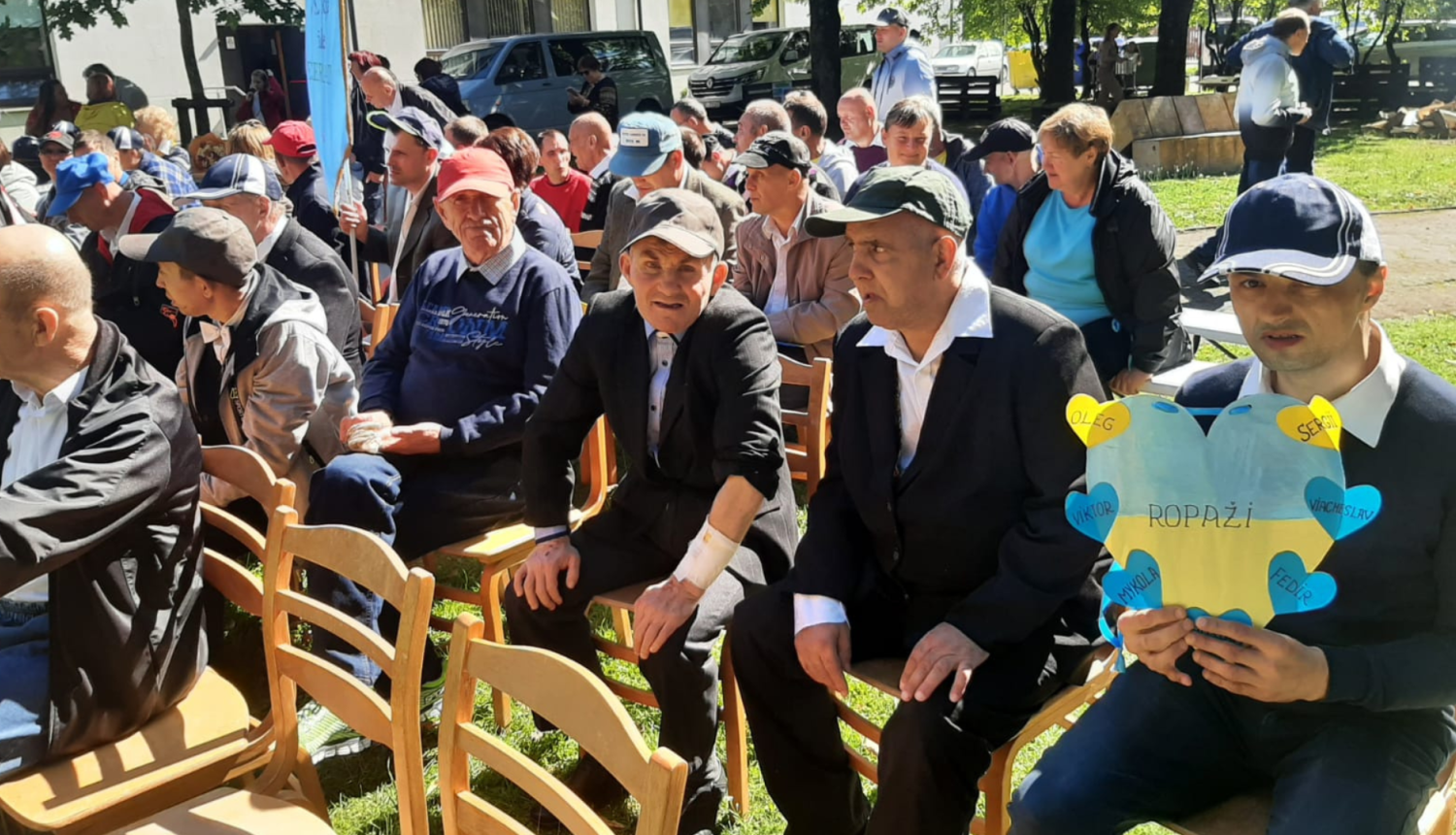 Pasākuma dalībnieki ar Ukrainas karoga krāsās krāsotu kartona sirdi rokās