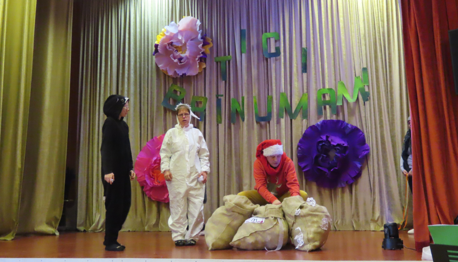 Dalībnieki uz skatuves rāda teatrālu priekšnesumu