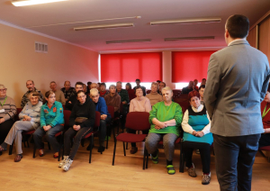 Zālē sēžiedzīvotāji, priekšā iestādes direktors vada kopsapulci