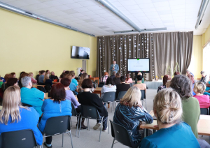 Zālē sēž darbinieki, priekšā iestādes direktors vada kopsapulci