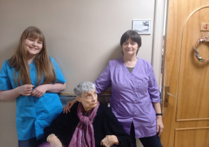 Smaidīga jauniete kopā ar iestādes darbinieci un iestādes iedzīvotāju