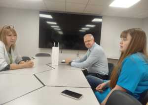 Jauniete ar filiāles darbinieci un vadītāju gaišā telpā sarunājas