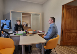 Kabinetā sēž divi cilvēki. Iestādes direktors un viņa ēna skolnieks