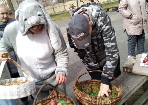 Divi cilvēli ņem krāsotās olas no diviem lielajiem groziem